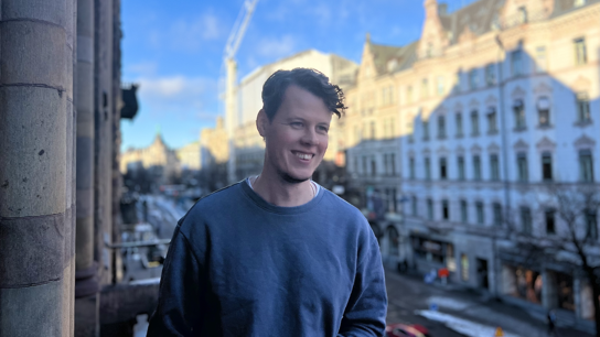 Porträttbild Oscar Tornquist på en balkong med staden i bakgrunden.