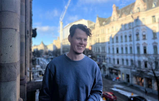 Porträttbild Oscar Tornquist på en balkong med staden i bakgrunden.