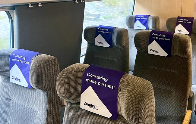 Tågstolar med Zington-brandade antimacassar med texten "Consulting made personal"
