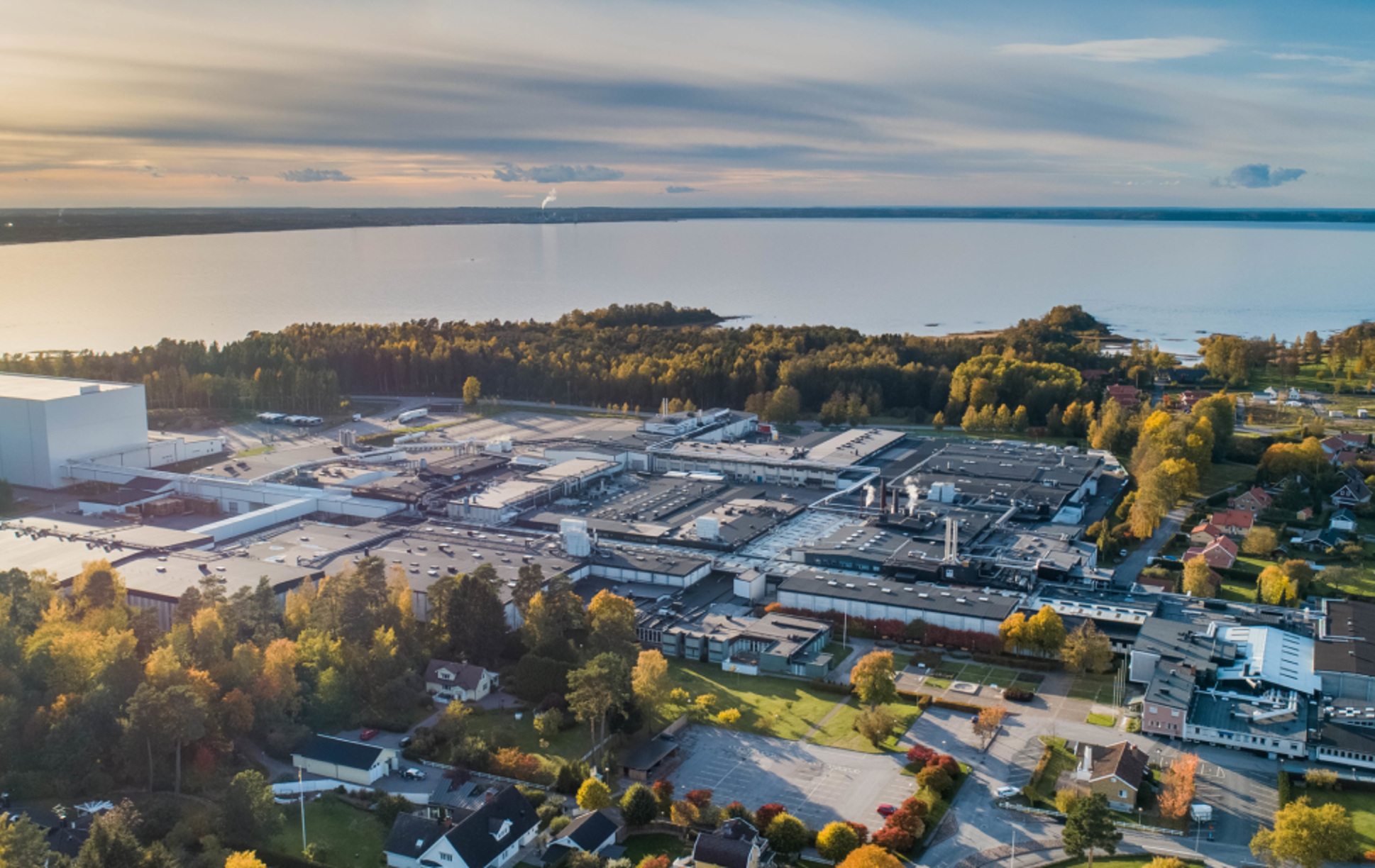 Flygfoto över ett industriområde med Vänern i bakgrunden.