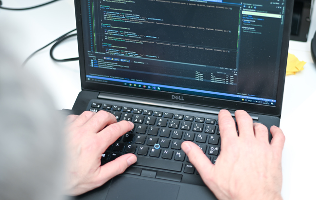 En närbild på en person skriver på en DELL laptop