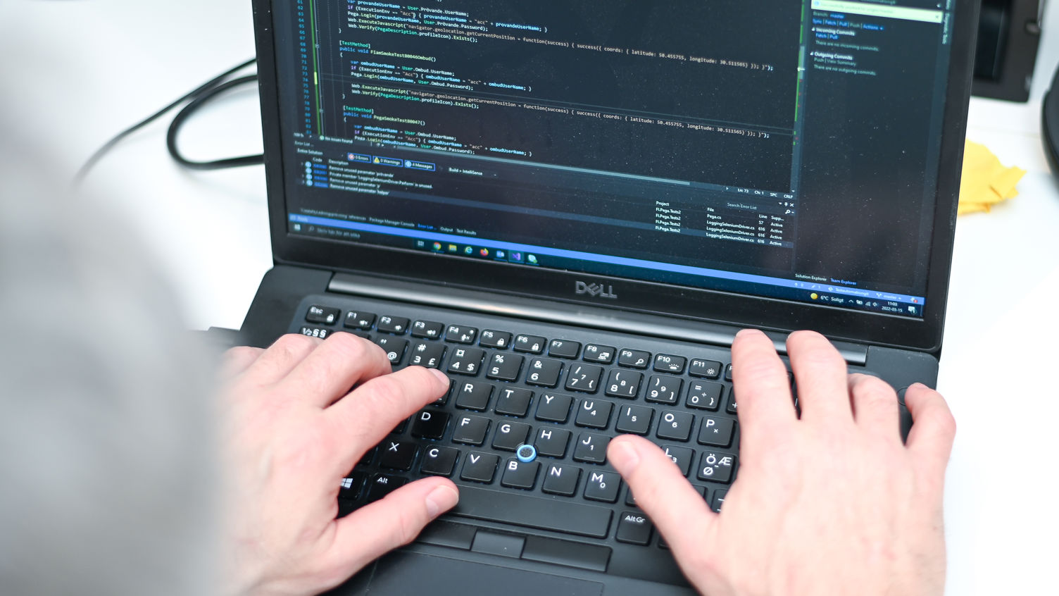 En närbild på en person skriver på en DELL laptop