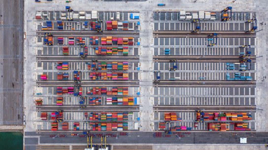 Flygfoto av många färgglada containers på en stor hamn.