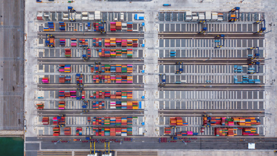 Flygfoto av många färgglada containrar på en stor lastplats.