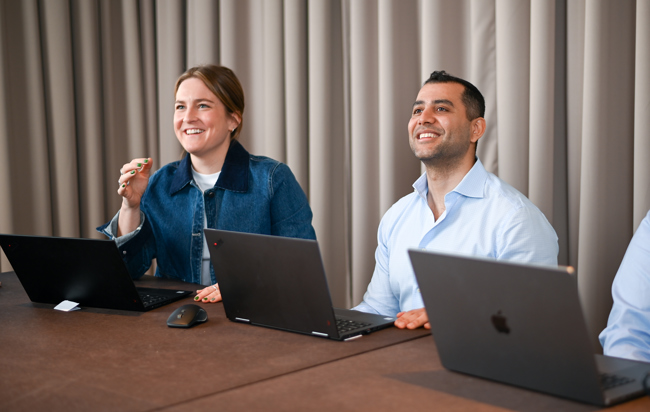 En man och en kvinna sitter vid ett bord med bärbara datorer.