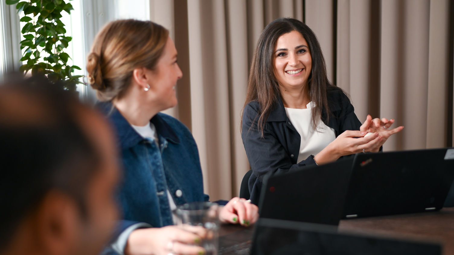 En grupp kvinnor som sitter bland sina arbets stationer och pratar.