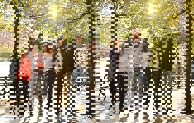 En grupp människor i en park som poserar för en bild.