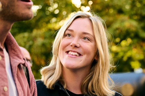 Leende Vendela Norrman en sensommarkväll med lummig bakgrund